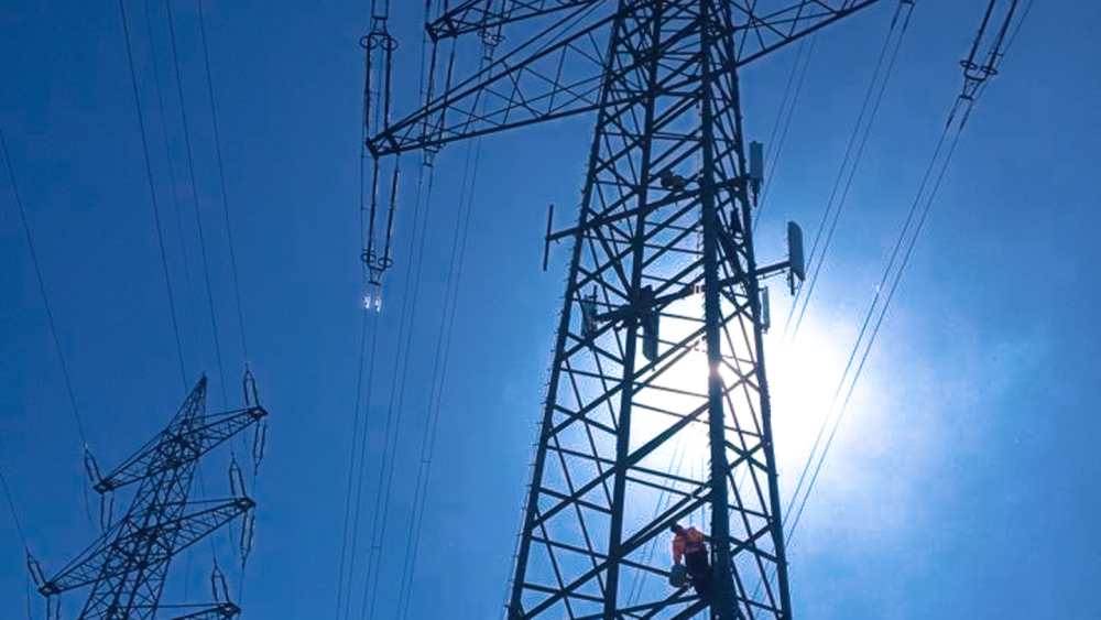 ABEL Antennenanlage an Hochspannungsmasten vor blauem Himmel